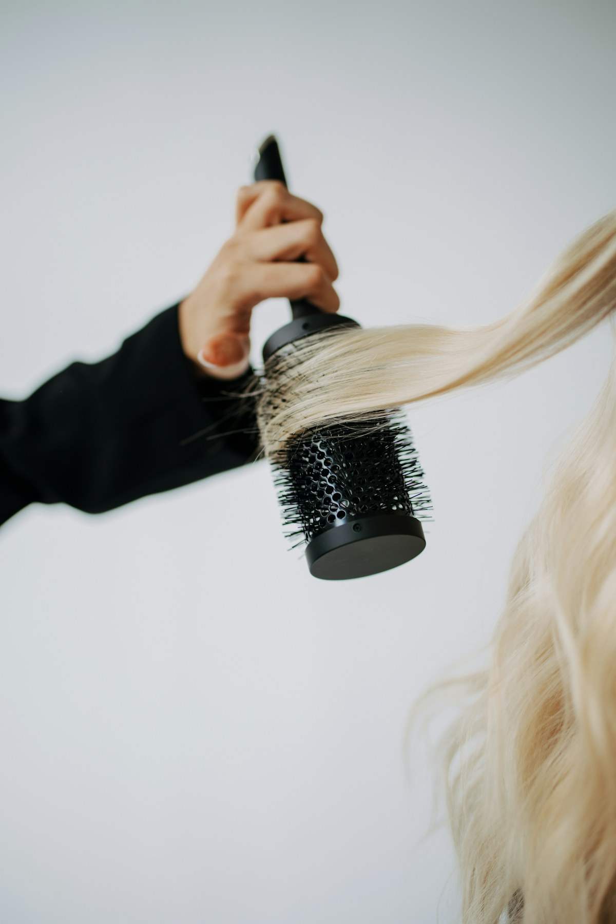 A round brush styling long hair during a blow dry